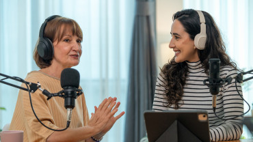 Kaksi henkilöä podcast-studiossa